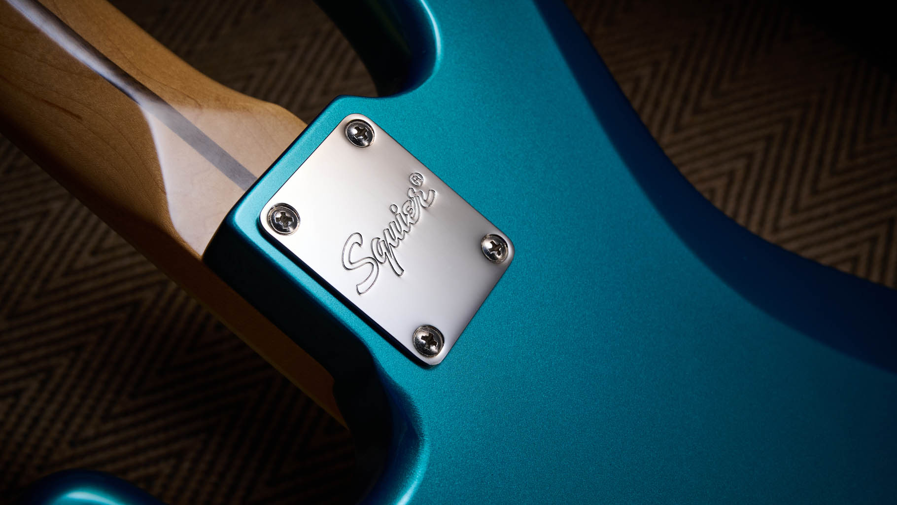 Squier Classic Vibe 70s Jazz Bass Active: finished in Ocean Turquoise, this keenly priced four-string is photographed in close-up with a patterned rug and wooden floor in the background.