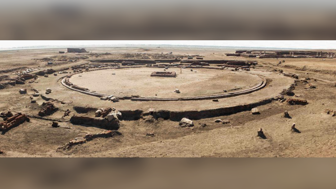 overview of a large circular brick temple being excavated in the desert