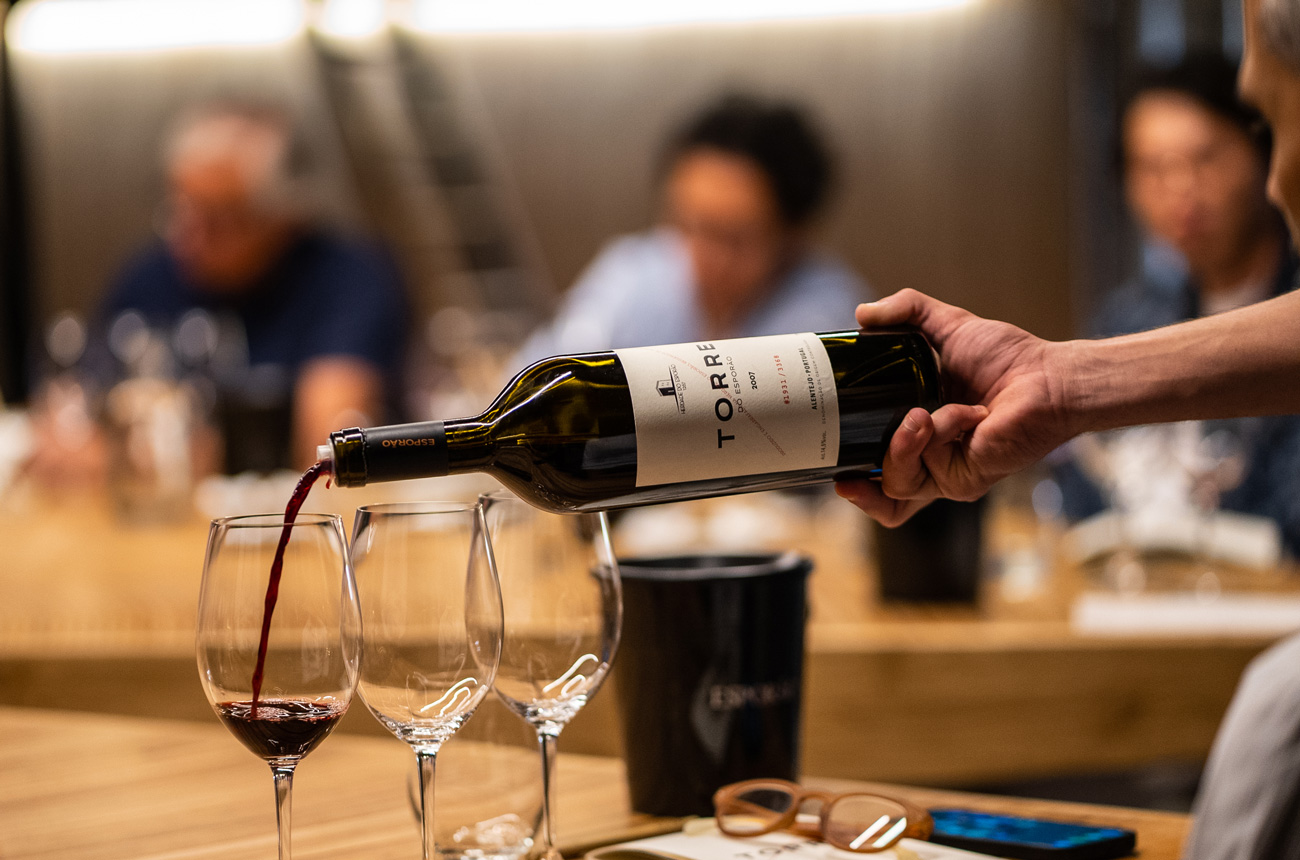 A hand pouring a bottle of wine