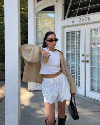 Shorts trends 2024: @mobinapeiman wears white lace, bloomer-style shorts with a camel-coloured cardigan