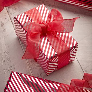 Wrapped present using red ribbon and candy striped wrapping