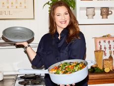 Drew Barrymore in a chic kitchen holding a Beautiful Pan filld with vegetables