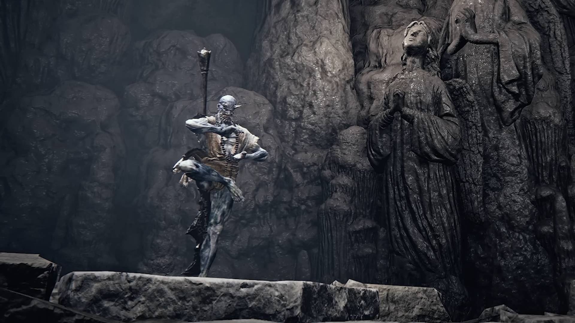 The Duskbloods oni character balancing on one leg in a cave with carved statues