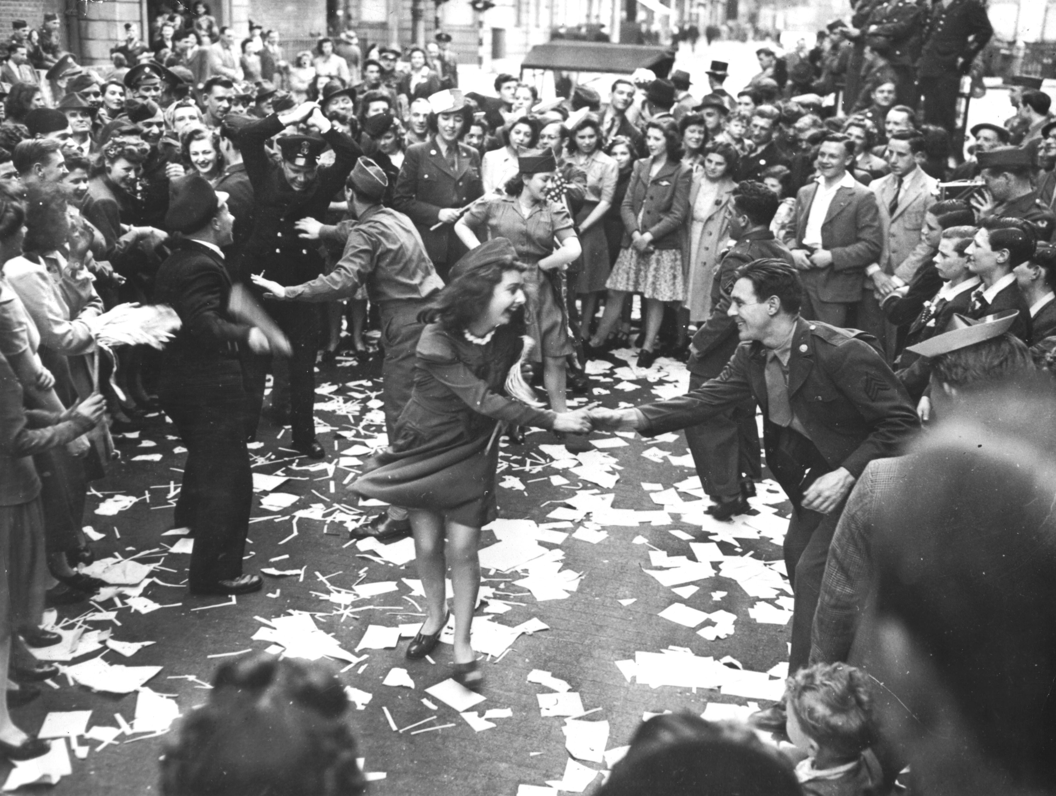 British girls, of the Picture Division of the London Office of War Information, dance in the street with American soldiers during the V-E Day celebrations in London, May 8, 1945
