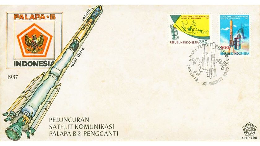 an envelope decorated with an illustration of a rocket and postmarked with two commemorative stamps for a satellite launch