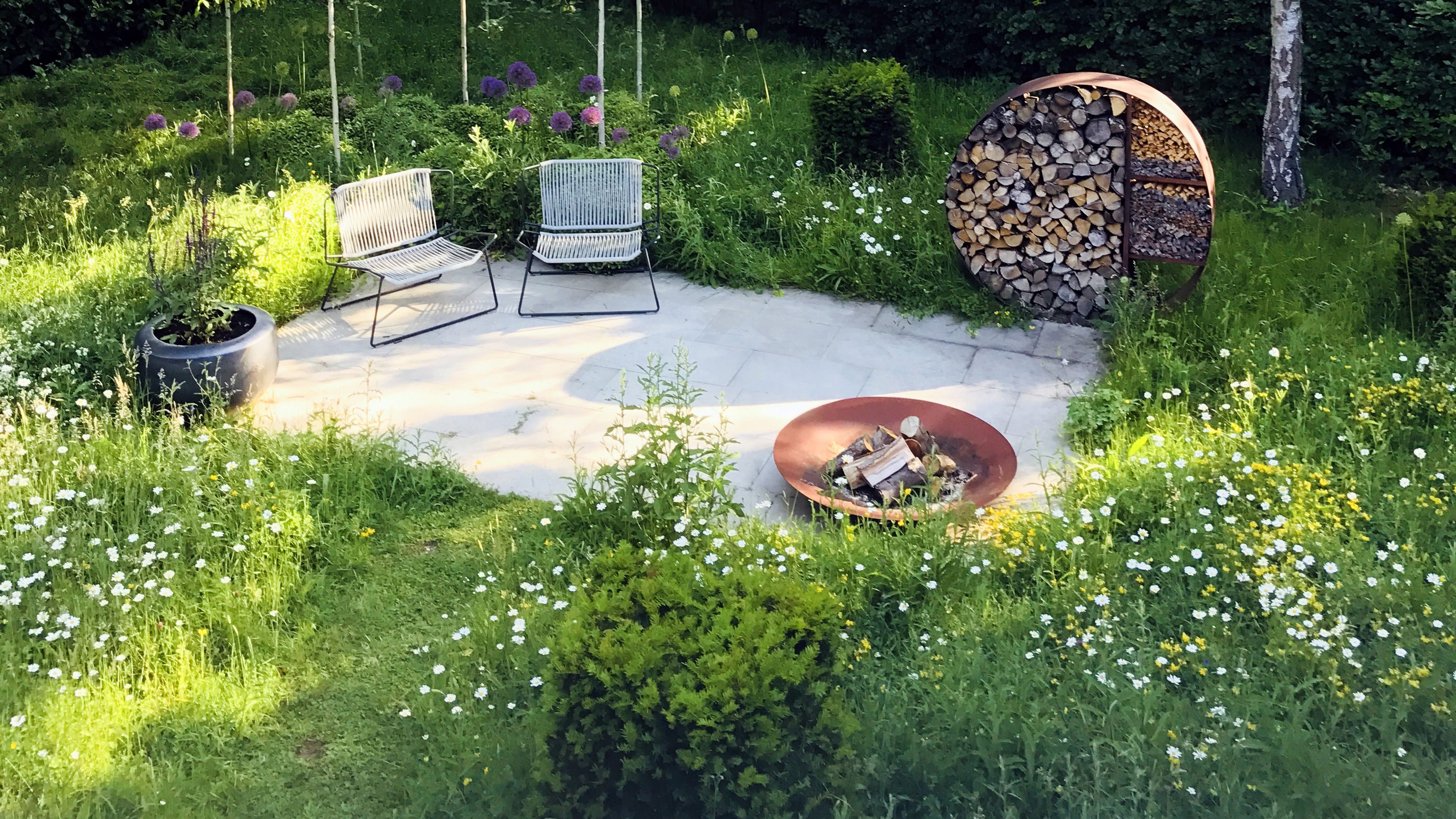 Image of Circle garden bed made of logs with wildflowers