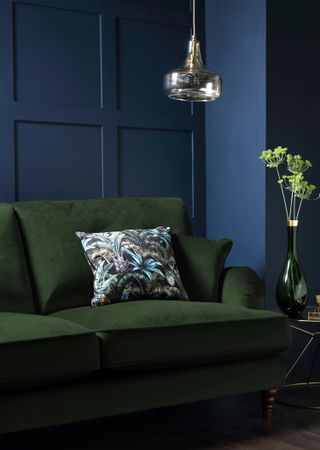 dark blue square wall panelling in living room with green chair
