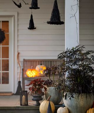 halloween front fall porch decor with witch hats and pumpkins