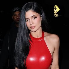 Kylie Jenner wearing a red latex halter dress and perspex heels