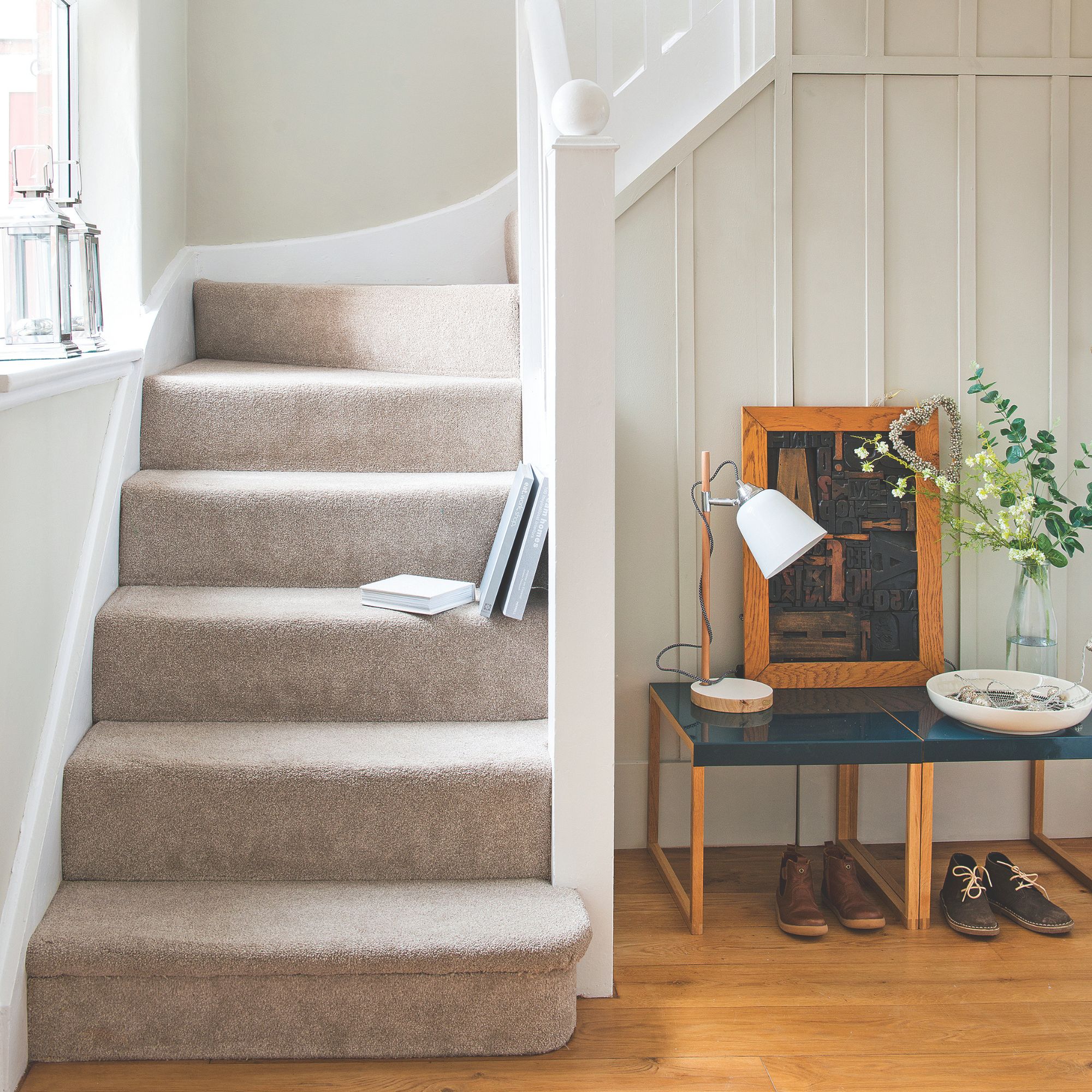 Hallway with wooden floor and carpeted stairs leading to the upstairs of the house