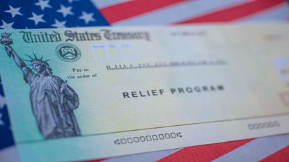 picture of government relief program check on top of an American flag