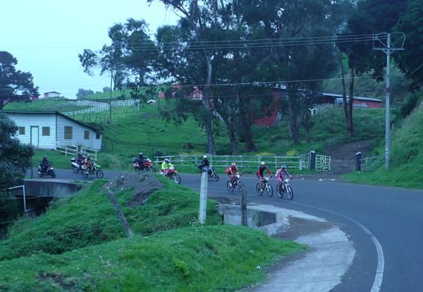 The three leaders round a bend going uphill