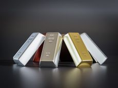 eight common precious metal bars arranged into prism on black background