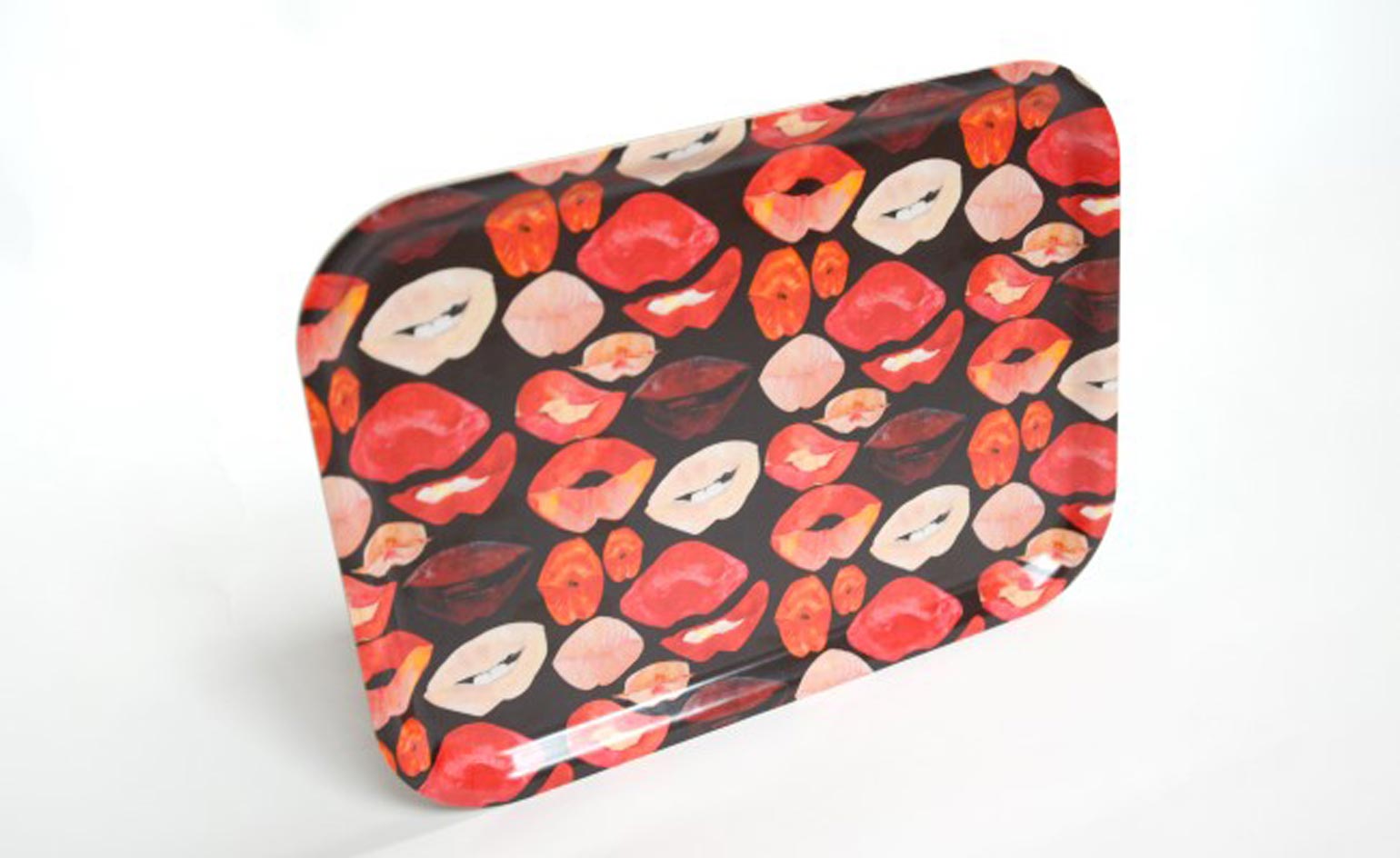 tray with lipstick lips in shades of red and pink. photographed horizontally against a white background