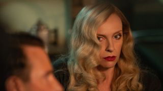Toni Collette looks at Bradley Cooper with worry in Nightmare Alley.