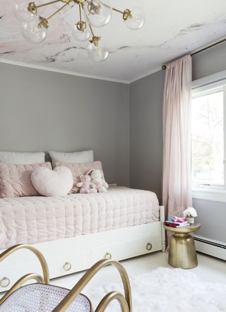 A bedroom with grey walls and pink ceiling