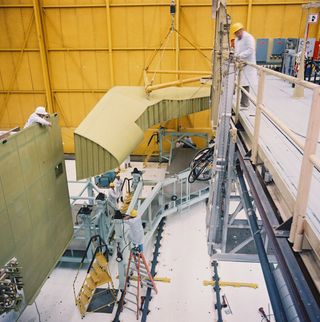 The left wing is being positioned for installation onto the mid-fuselage at the Rockwell Palmdale facility on February 19, 1988.
