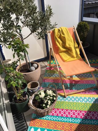 bold outdoor rug and deckchair in a small courtyard space