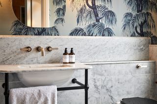 A luxurious marble bathroom with blue palm tree wallpaper