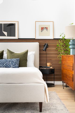 neutral bedroom with wooden slat design on walls with small shelf