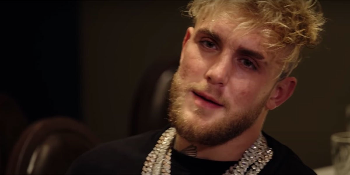 Jake Paul with a black shirt on, rocking some gold chains.