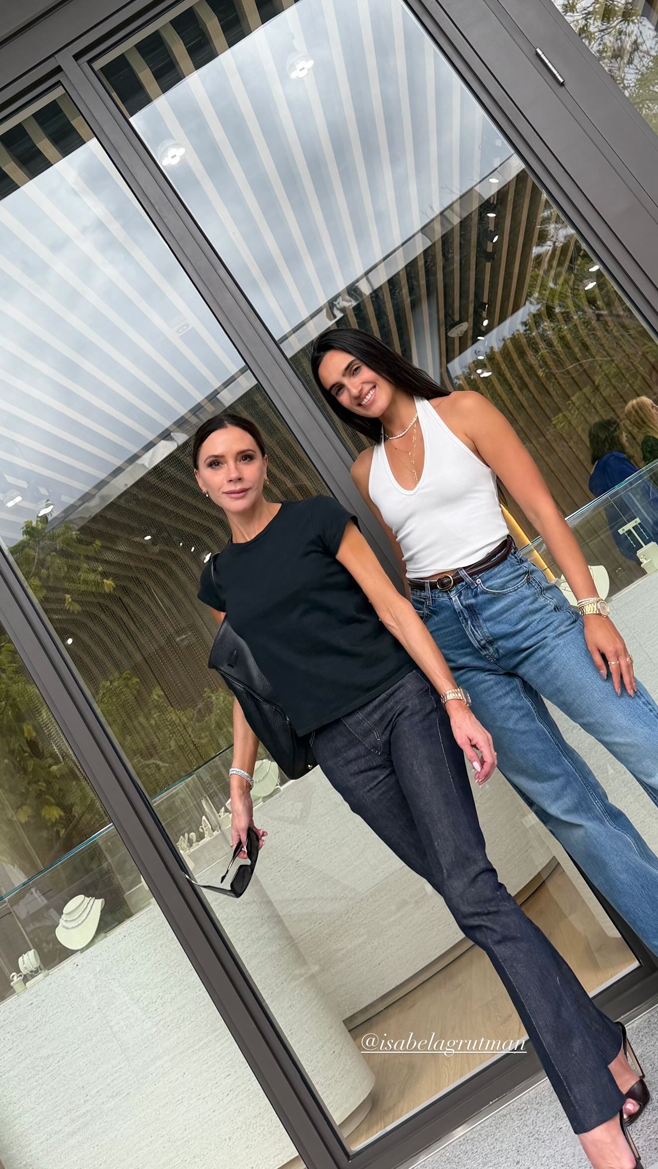Victoria Beckham wears dark wash jeans with peep-toe shoes.