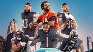 A promotional image for 'Hard Knocks: Training Camp with the Chicago Bears' featuring players standing over a silver football with the Chicago skyline behind