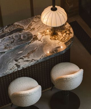 An overhead view of a marble bar countertop and barstools