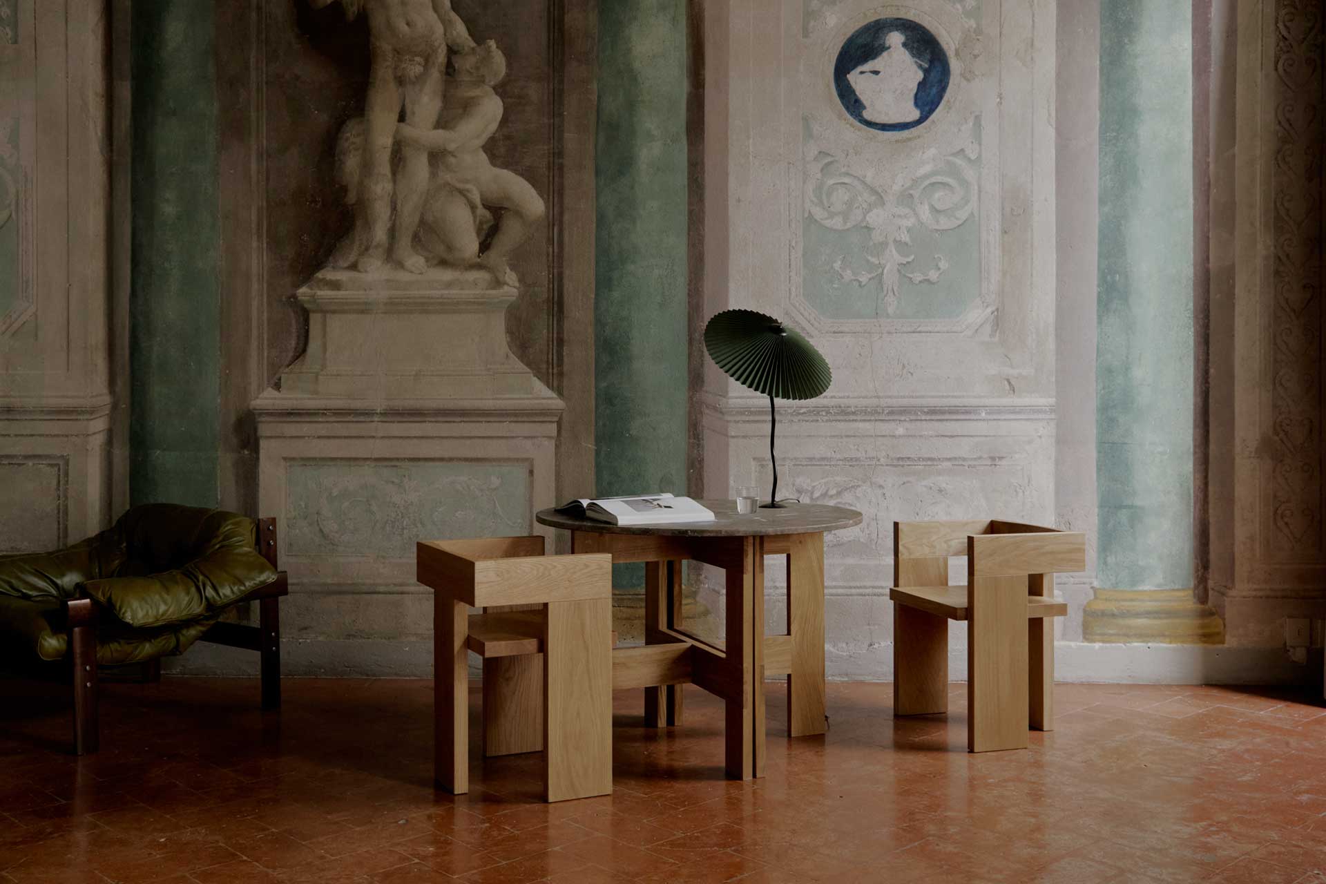 A Florence palazzo has been reinvented with mid-century modern furniture in wood that contrast with its frescoed walls.