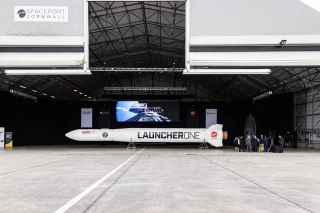 LauncherOne model rocket is placed horizontally in a large hangar at spaceport Cornwall.