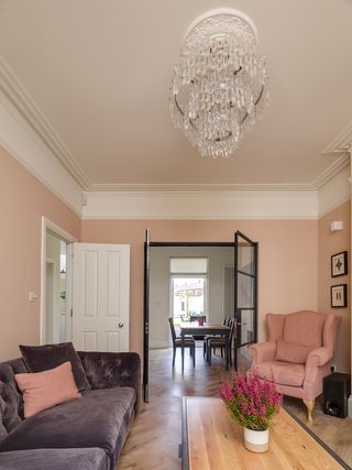 pink living room in period house with original features such as mouldings and ceiling rose