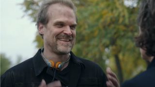 David Harbour laughing in disbelief while in conversation outside in Gran Turismo.