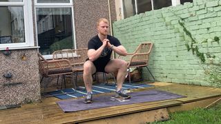 Fit&Well fitness writer Harry Bullmore performing a squat as part of an Arnold Schwarzenegger bodyweight workout challenge