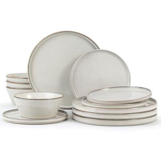 A set of 12 dinnerware set. Cream plates with metallic gold trims