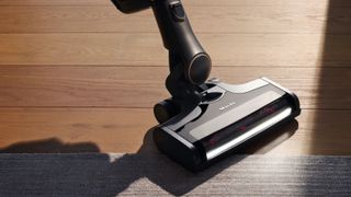 Miele Triflex HX2 Pro vacuuming wooden floor and area rug