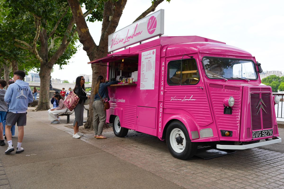People ordering food from a pink food truck on the London Southbank