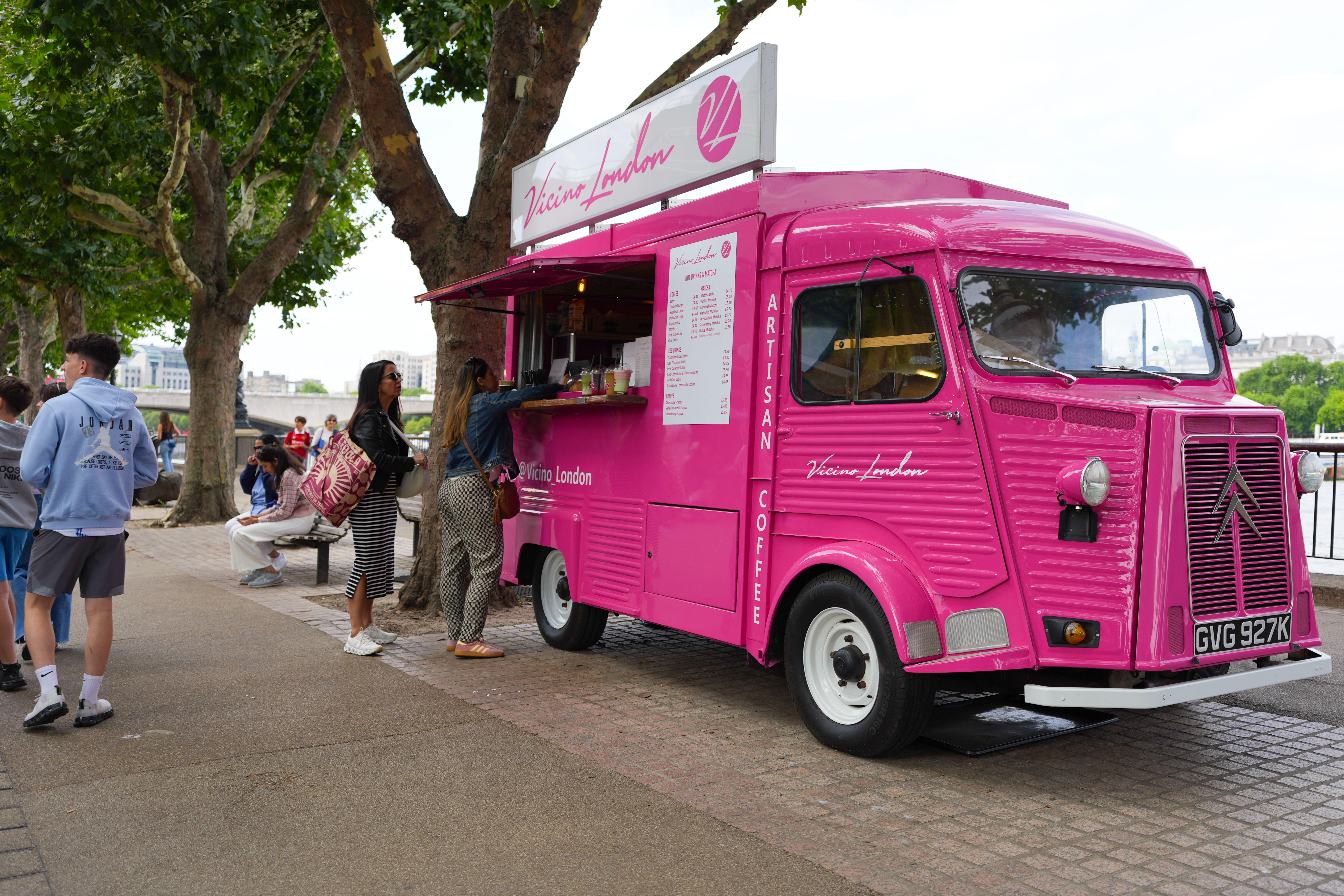People ordering food from a pink food truck on the London Southbank