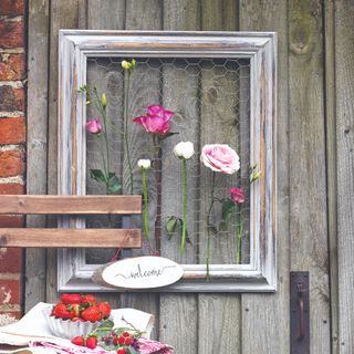 A garden flower display made with an upcycled picture frame and chicken wire