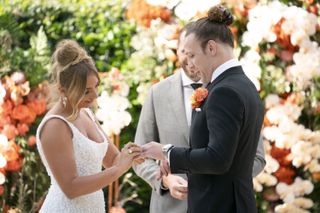 Eden puts a ring on Jayden's finger at their wedding.