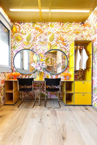 Changing room at Teatro degli Arcimboldi with colourful wallpaper and yellow vanity furniture