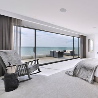 bedroom with rocking chair glass sliding door and white carpet