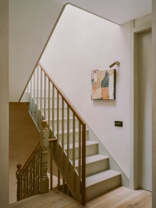Stairway with hung artwork at Artists' House, London by Mitchell + Corti Architects