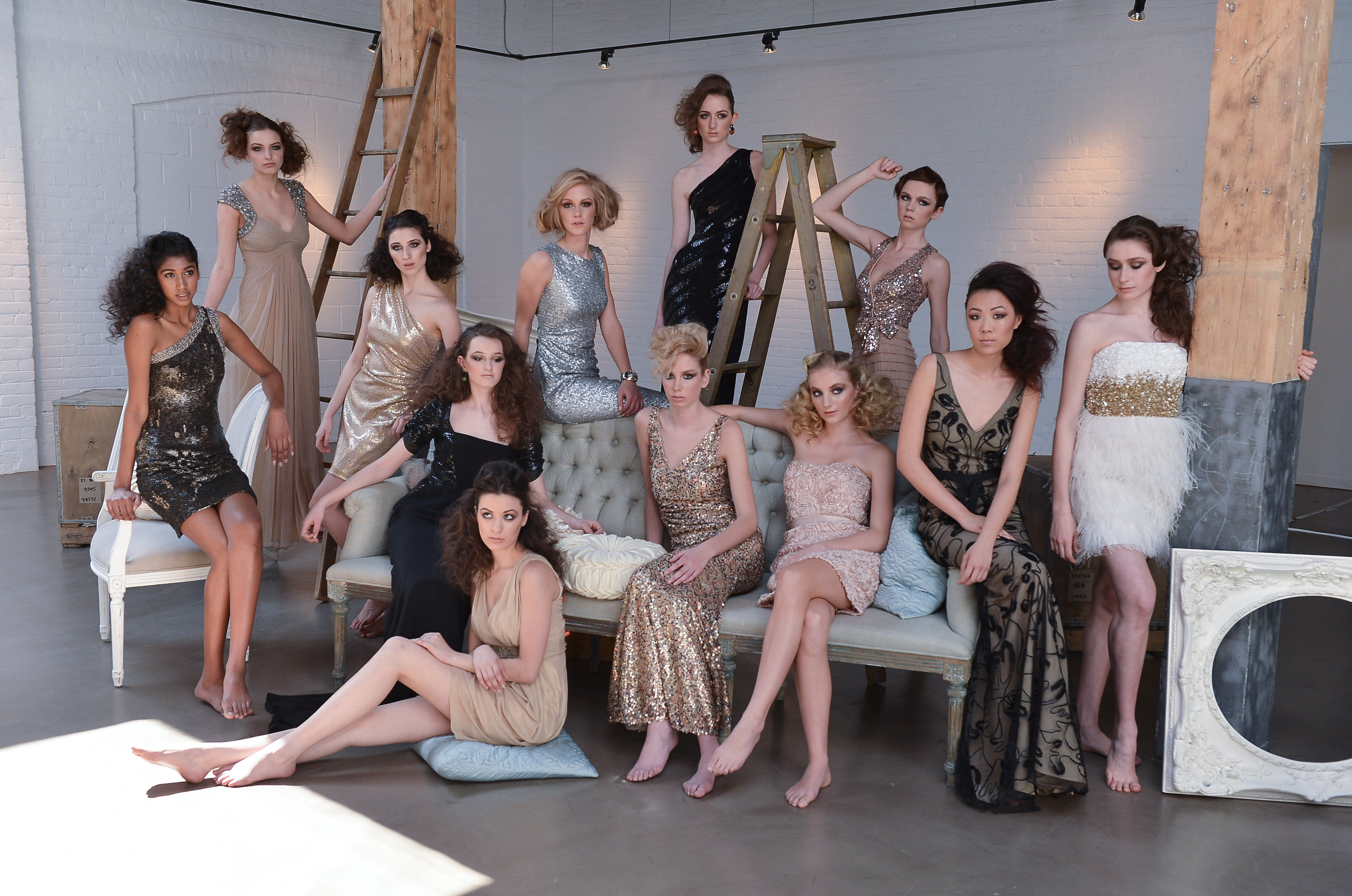models in silver and gold pose around a couch on america's next top model