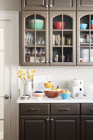 brown kitchen cabinets with colorful bowls