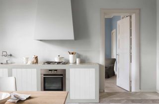 pale gray and white kitchen, scandi style, blonde wood table, white chairs, white accessories