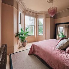 bedroom with beige walls and pink bed linen