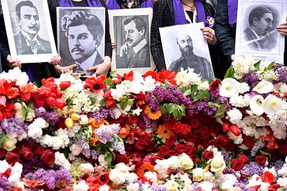 People hold photos of victims of the 1915 Armenian genocide.