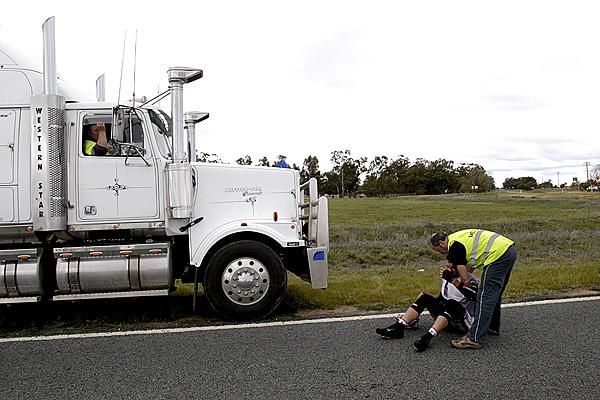 A truck driver has a front row seat as he watches American Curtis Gunn (Fly V Australia) attended to a after falling on stage three.