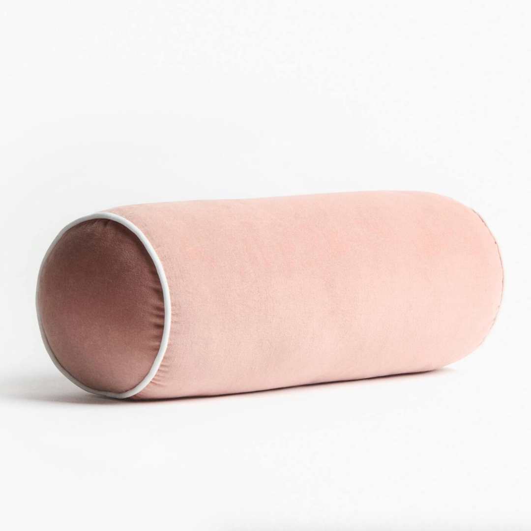 pink lumbar pillow with white piping