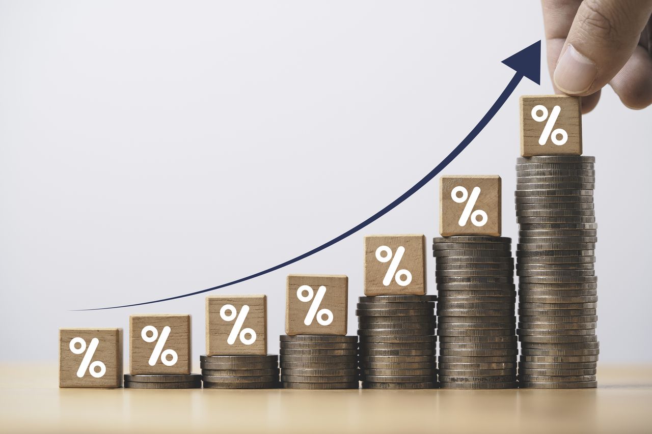 Increasing coin stacking with up arrow and percentage sign for increase financial interest rate and business investment growth from dividend concept.